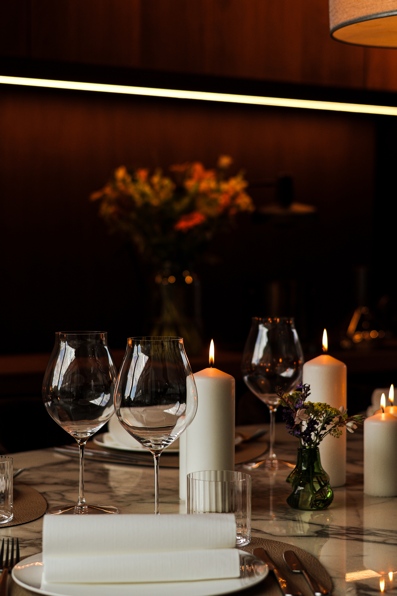 Gedekte tafel met wijnglazen, kaarsen en bloemen in Maison Parole